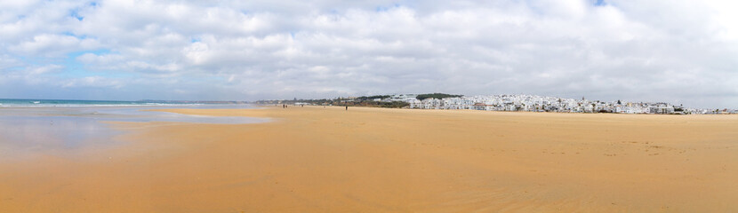 Fototapeta na wymiar Panoramic view of the beach and the sea with the white houses town of Conil, Cadiz, Spain