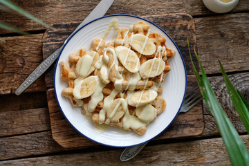 Waffles with banana and white chocolate. Wooden background. Top view. 