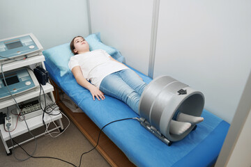 Girl receiving magnetotherapy treatment in modern clinic