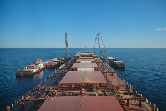 Transshipment of grain products at anchorage, barges, floating cranes and bulk carrier