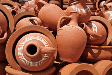 Obraz premium Close-up view of broken and intact clay pots piled in market.