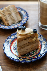 Piece of Banana cake with blueberries and white chocolate. Wooden background, side view