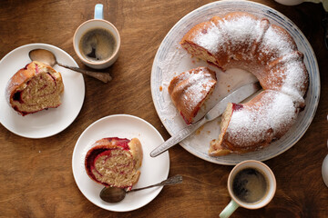 Raspberry roll wreath. Brioche. Top view, wooden background, coffee, powdered sugar, yeast buns. 