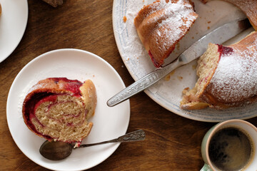 Raspberry roll wreath. Brioche. Side view, wooden background, coffee, powdered sugar, yeast buns. 