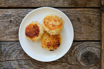 Cottage cheese pancakes. Side view, wooden background. Syrnik