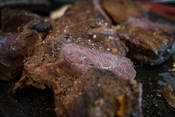 Braised beef cheeks cooked in red wine sauce on cutting board. Slow cooked meat stew.