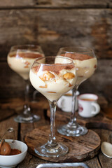 Portioned tiramisu in a glass. Wooden background, side view