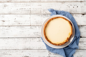 Tasty homemade cheesecake on white wooden table