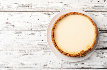 Tasty homemade cheesecake on white wooden table