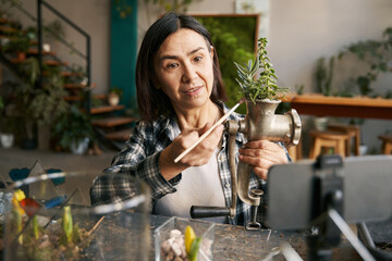 Asian female giving video lesson on floristry in workshop