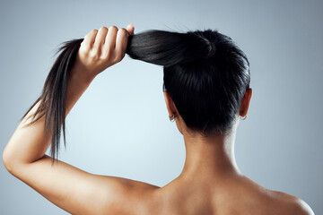 .. Studio shot of a young woman with against a grey background.