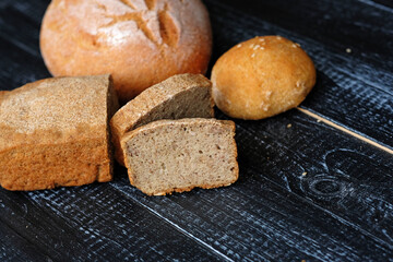 Traditional bread of different shapes on a black wooden table