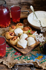 Buns with cinnamon and cream sauce. cherry compote. side view.