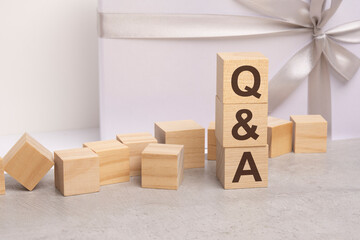 Obraz premium qa - letters on wooden cubes. concept on white gift box background