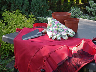 BHP w ogrodzie, czerwony fartuch, rękawiczki ogrodowei metalowa łopatka, Gardening tools, safe...