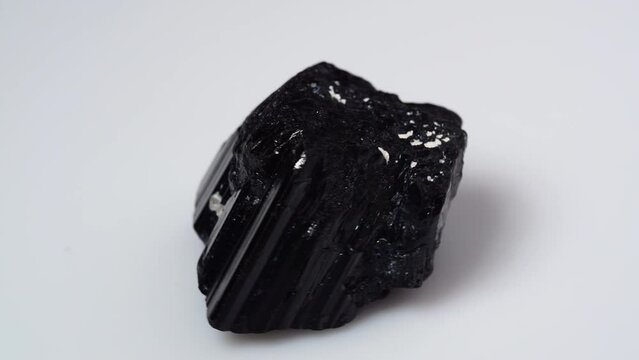 black tourmaline scherl rough specimen on the white background turning table