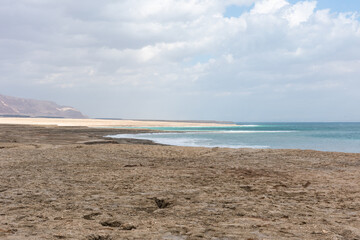 Exotic view of the sinkhole area of the Dead Sea on a stormy winter day. PhotoStorm and rain at the Dead Sea coastline. Salt crystals at sunset. The texture of the Dead sea. Salty seashore. High