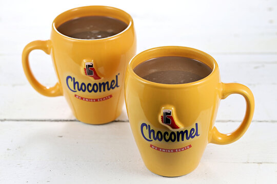 WIEHL, GERMANY - APRIL 3, 2022: pair of Chocomel mugs with chocolate-flavored milk on wooden background