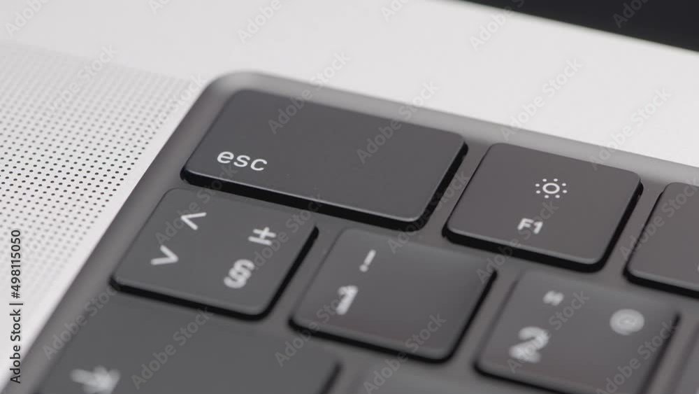 Aufkleber part of the black keyboard in the frame. action. black keyboard in a silver laptop. corner with butt
