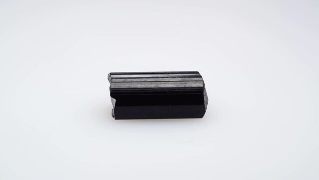 black tourmaline scherl rough specimen in the tweezers