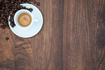 Cup of fresh espresso in white cup on walnut table