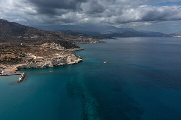 Fototapeta na wymiar Mediterranean coastline with mountains, white rocks and clear sea under dramatic sky, Crete, Greece