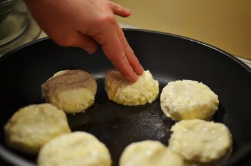 Housewife cooking pancakes in a pan