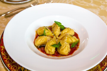 Italian ravioli with tomato sauce are on a plate