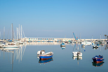 Sea Port whit Luxury yachts. Sailing boats in a quiet harbor. Clear blue sky and calm sea. Bari, Italy.