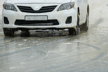 Naklejka premium car closeup on a slippery wet road during inclement weather concept bad road conditions and road safety