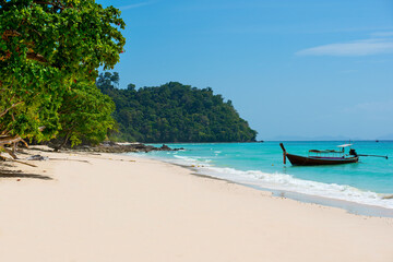 Fototapeta na wymiar Beautiful empty exotic tropical beach with white clean sand and crystal clear sea water. Island landscape with a view to Longtail boat. Koh Rok Island, Thailand.