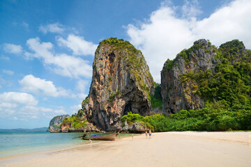 Amazing tropical view of Phra Nang Beach. People on the white sand, long-tail boats in the sea, Ao Nang, Krabi, Thailand