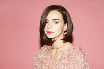 close up portrait of young fashionable woman with Bob haircut isolated on pink background