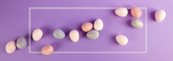 Happy Easter concept. Easter composition with colorful eggs on purple background. Celebration design. Banner. Flat lay. Copy space.