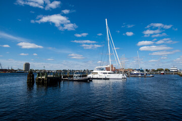 Fototapeta na wymiar The Norfolk, Virginia, Downtown Complex on the Chesapeake Bay Looking atBoats Moored at a Dock from Town Point Park.