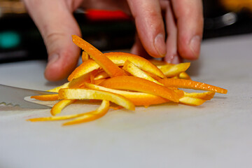 Bartender cuts orange peel for cocktail