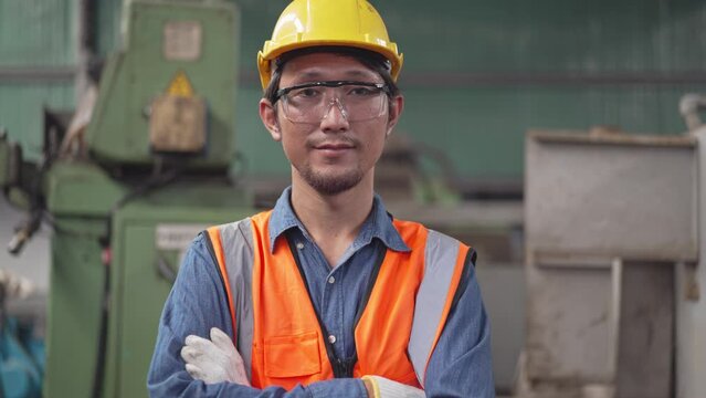 Zoom in portrait Asian male engineer of technician worker in safety clothing smiling to camera. Machine inspector or mechanic standing in a factory. people working for industrial construction site