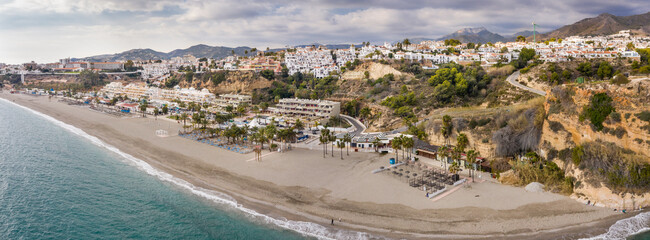 Panoramic aerial view of Burriana beach situated in Nerja Village , Malaga - Spain. Perspective from above of the must big and touristic beach from the city. Cloudy day. Typically Spanish village.