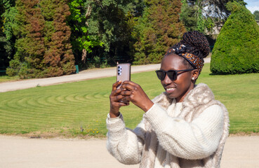 Young woman taking a photo with her smartphone outdoors
