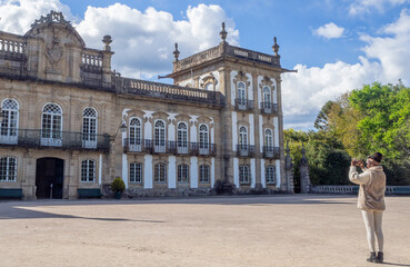 Obraz premium Young woman taking a photo of Brejoeira palace in Monção Portugal