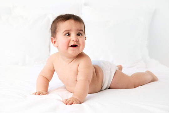 Happy baby boy lying on tummy pushing on arms