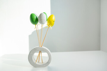 easter decorations easter eggs on a white background with a shadow from the sun in a vase with copy...