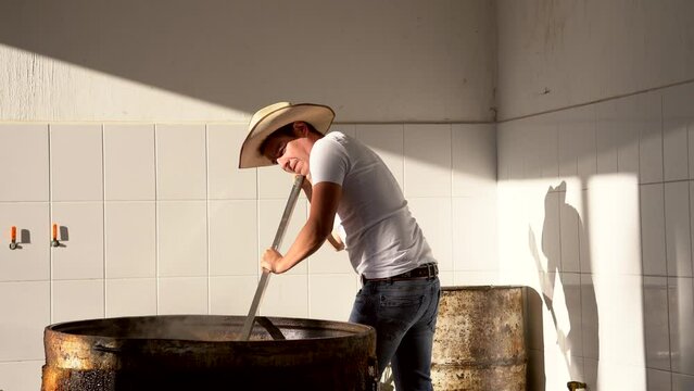Muchacho se&ntilde;or trabajador preparando haciendo y cocinando rico y delicioso platillo t&iacute;pico carnitas comida carne de cerdo puerco en manteca aceite