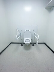 View of a disabled toilet in a pubic Bathroom, with handels 
