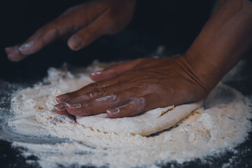 flour falling on a dark table. preparing the homemade bread making process. photo inside.