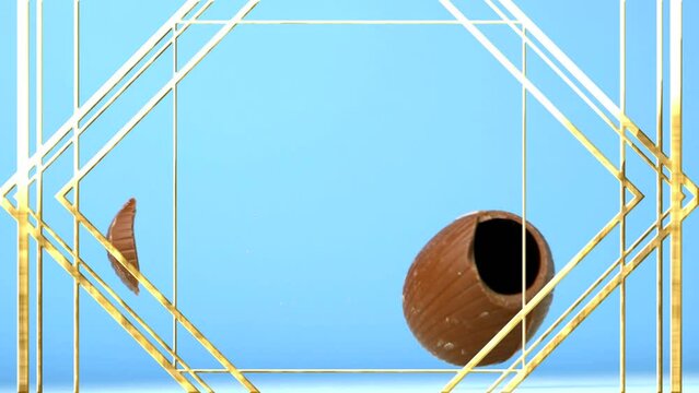 Animation of gold line shapes over chocolate easter egg falling and breaking, on blue