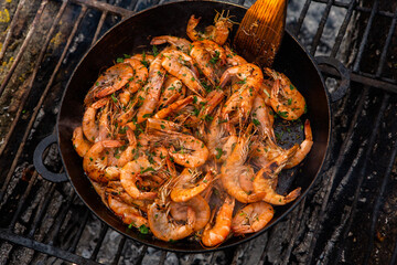 crispy fresh shrimp cooked on a frying pan in the wild. Rest in nature with fresh food
