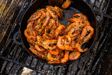 crispy fresh shrimp cooked on a frying pan in the wild. Rest in nature with fresh food
