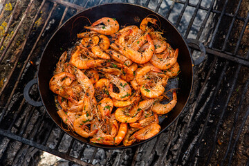 crispy fresh shrimp cooked on a frying pan in the wild. Rest in nature with fresh food
