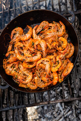 crispy fresh shrimp cooked on a frying pan in the wild. Rest in nature with fresh food
